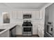 Modern kitchen with stainless steel appliances, white cabinets and countertops, and a gas range at 5458 Walton Heath Ave, Las Vegas, NV 89142