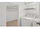 Functional laundry room featuring a modern washer and dryer, shelving, and plank flooring at 5458 Walton Heath Ave, Las Vegas, NV 89142