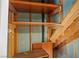 Close-up of the unfinished storage space beneath the stairs with wood shelving and supports at 5458 Walton Heath Ave, Las Vegas, NV 89142