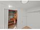 Bright walk-in closet featuring wooden shelving, storage space, and a convenient access door at 5458 Walton Heath Ave, Las Vegas, NV 89142