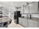Modern kitchen features granite countertops, gray cabinets, stainless appliances, and breakfast bar at 6106 Castle Gardens Ave, Las Vegas, NV 89130