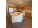 Kitchen features an island, wooden cabinetry, and modern appliances at 6425 Sierra Sands St, North Las Vegas, NV 89086