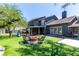 Backyard featuring a fire pit with seating, artificial turf, and ample shade at 7135 Polaris Ave, Las Vegas, NV 89118