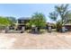 Exterior view of a house with a large yard, mature trees, and a secure gated entrance at 7135 Polaris Ave, Las Vegas, NV 89118