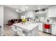Open kitchen with white cabinets, marble countertops, stainless steel appliances, and an island with seating at 7135 Polaris Ave, Las Vegas, NV 89118