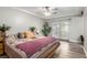 Serene main bedroom with wood-look tile, ceiling fan, and sliding glass doors to outdoor space at 7135 Polaris Ave, Las Vegas, NV 89118