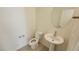 Bathroom featuring a pedestal sink, toilet, and round mirror at 7375 Davenbury St, Las Vegas, NV 89113