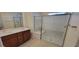 Bathroom featuring a glass shower, dual sinks, and wood cabinets at 7375 Davenbury St, Las Vegas, NV 89113