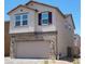 Two-story home featuring stone accents and a beige-colored stucco exterior, showcasing modern design and curb appeal at 7375 Davenbury St, Las Vegas, NV 89113