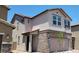 Two-story home with neutral stucco, stone accents, and a well-manicured yard; offering modern design and curb appeal at 7375 Davenbury St, Las Vegas, NV 89113