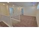 Upstairs loft area with neutral carpet and staircase with white railing at 7375 Davenbury St, Las Vegas, NV 89113