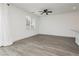 Spacious living area featuring gray wood floors and a large window, perfect for relaxing or entertaining at 7777 Vino Vranec Ct, Las Vegas, NV 89113