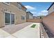 Backyard showcasing a brick-paved patio with a sliding glass door entry and a small strip of artificial grass at 8011 Cavazzo Ave, Las Vegas, NV 89178