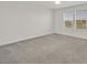 Bright bedroom featuring neutral carpeting and a ceiling fan, offering ample natural light at 8011 Cavazzo Ave, Las Vegas, NV 89178