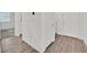 Hallway with wood-look flooring leading to doors, bathroom, and bedroom at 8011 Cavazzo Ave, Las Vegas, NV 89178