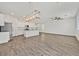 Bright, open-concept living space with wood flooring, a ceiling fan, and an eat-in kitchen with stainless steel appliances at 8011 Cavazzo Ave, Las Vegas, NV 89178