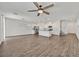 Bright, open-concept living space with wood flooring, a ceiling fan, and an eat-in kitchen with stainless steel appliances at 8011 Cavazzo Ave, Las Vegas, NV 89178