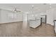 Bright, open-concept living space with wood flooring, a ceiling fan, and an eat-in kitchen with stainless steel appliances at 8011 Cavazzo Ave, Las Vegas, NV 89178