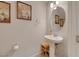 A half bath with pedestal sink, updated fixtures, wall art, and a small wooden step stool at 8176 Duncan Peak Ct, Las Vegas, NV 89139