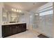 Bright bathroom featuring a glass shower, dark cabinets, and large mirrors at 8176 Duncan Peak Ct, Las Vegas, NV 89139