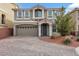 Two-story home featuring neutral stucco, paver driveway, shutters, and a two car garage at 8176 Duncan Peak Ct, Las Vegas, NV 89139