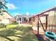 Grassy backyard featuring a covered patio, a tire swing and a wood fence at 8220 Desert Beach Dr, Las Vegas, NV 89128