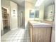 Bathroom with double sinks, tile flooring, a large mirror, and an adjacent walk-in closet at 8220 Desert Beach Dr, Las Vegas, NV 89128