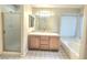 Bathroom featuring double sinks, a large mirror, a bathtub, and a walk-in shower at 8220 Desert Beach Dr, Las Vegas, NV 89128
