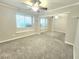 Neutral carpeted bedroom featuring a ceiling fan, window bench and mirrored closet doors at 8220 Desert Beach Dr, Las Vegas, NV 89128
