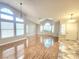 Spacious living room featuring hardwood floors, high ceilings, large windows, and modern lighting fixtures at 8220 Desert Beach Dr, Las Vegas, NV 89128