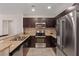 A spacious kitchen featuring dark wood cabinets, stainless steel appliances, and granite countertops at 8255 Las Vegas Blvd # 1905, Las Vegas, NV 89123
