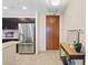 Close up of a stainless steel refrigerator, modern entry door, and small console table in a kitchen setting at 8255 Las Vegas Blvd # 1905, Las Vegas, NV 89123