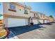 Exterior view showcasing attached garages in a townhouse community with well-maintained landscaping and ample parking spaces at 901 Nevada Sky St, Las Vegas, NV 89128
