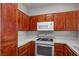 Well-equipped kitchen featuring wood cabinets, white appliances, and tiled countertops, providing a functional cooking space at 901 Nevada Sky St, Las Vegas, NV 89128