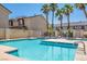 Community pool with clear blue water, palm trees, and nearby lounge area for relaxing at 901 Nevada Sky St, Las Vegas, NV 89128