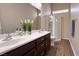 Bathroom featuring a double sink vanity, dark wood cabinets, and a glass-enclosed shower at 904 Swift Bear St, Henderson, NV 89002