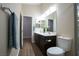 Bathroom featuring a double sink vanity, dark wood cabinets, and a glass-enclosed shower at 904 Swift Bear St, Henderson, NV 89002