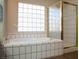 Bathroom featuring a soaking tub with white tiled walls and a gold trimmed shower at 904 Swift Bear St, Henderson, NV 89002