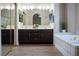 Bathroom featuring a double vanity, mirrors, a soaking tub, and hardwood floors at 904 Swift Bear St, Henderson, NV 89002