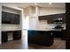 Spacious kitchen with dark cabinets, stainless steel appliances, an island, and a built-in desk area at 904 Swift Bear St, Henderson, NV 89002