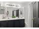 Elegant bathroom with dual sinks, dark cabinetry, and tiled shower and tub at 9105 Chenin Ave, Las Vegas, NV 89129