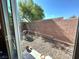 Private gravel backyard featuring a brick wall, greenery and an open space, perfect for entertaining at 9148 Patrick Henry Ave, Las Vegas, NV 89149