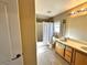 A well-lit bathroom featuring double vanity, tiled floors, and a shower-tub combo with a white curtain at 9148 Patrick Henry Ave, Las Vegas, NV 89149