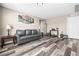 Comfortable living room featuring a gray sofa, stylish floors, and neutral decor at 9163 W Torino Ave, Las Vegas, NV 89148