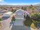 Aerial view of home with an attached three-car garage, lush lawn, desert landscaping, and a detached shop at 9435 Westwind Rd, Las Vegas, NV 89139