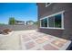 This backyard has a stone tiled patio, gravel, wood Adirondack chairs, and a stone fire pit at 9451 Lunar Ray St, Las Vegas, NV 89143