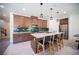 Stylish kitchen showcasing dark wood cabinetry, stainless steel appliances, and a spacious island with seating at 9451 Lunar Ray St, Las Vegas, NV 89143