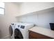 A practical laundry room with modern washer and dryer units, and counter space for folding and sorting at 9451 Lunar Ray St, Las Vegas, NV 89143