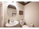 Elegant powder room with modern fixtures, a unique mirror, and neutral wall colors at 9451 Lunar Ray St, Las Vegas, NV 89143