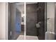 Contemporary shower with dark tile surround and glass enclosure at 9451 Lunar Ray St, Las Vegas, NV 89143